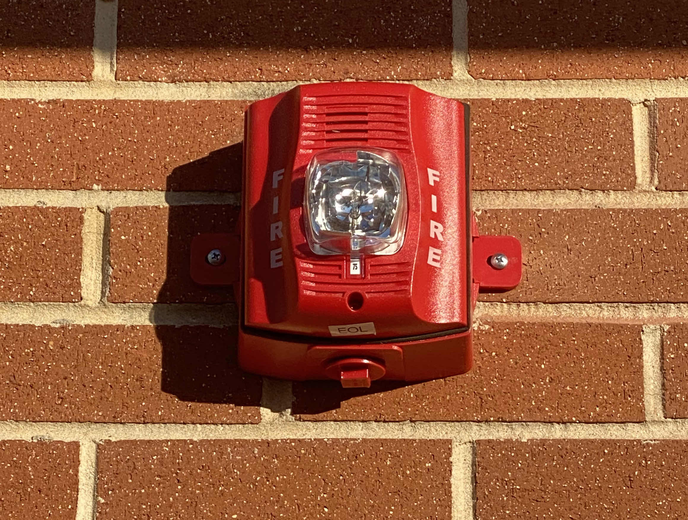 fire alarm against a brick wall 